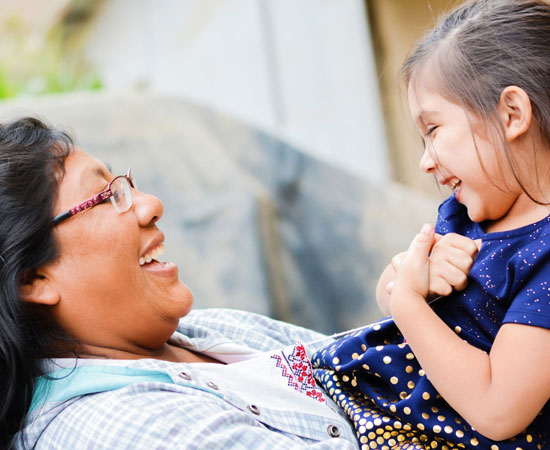 A smiling mother holding her young daughter