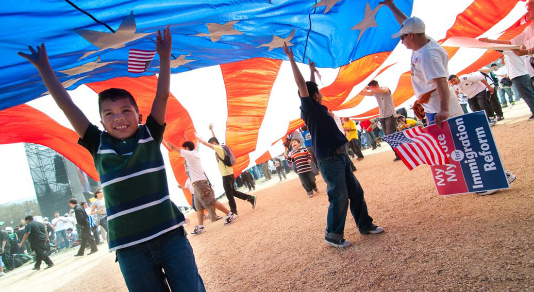 A group of kids playing under a giant American flag