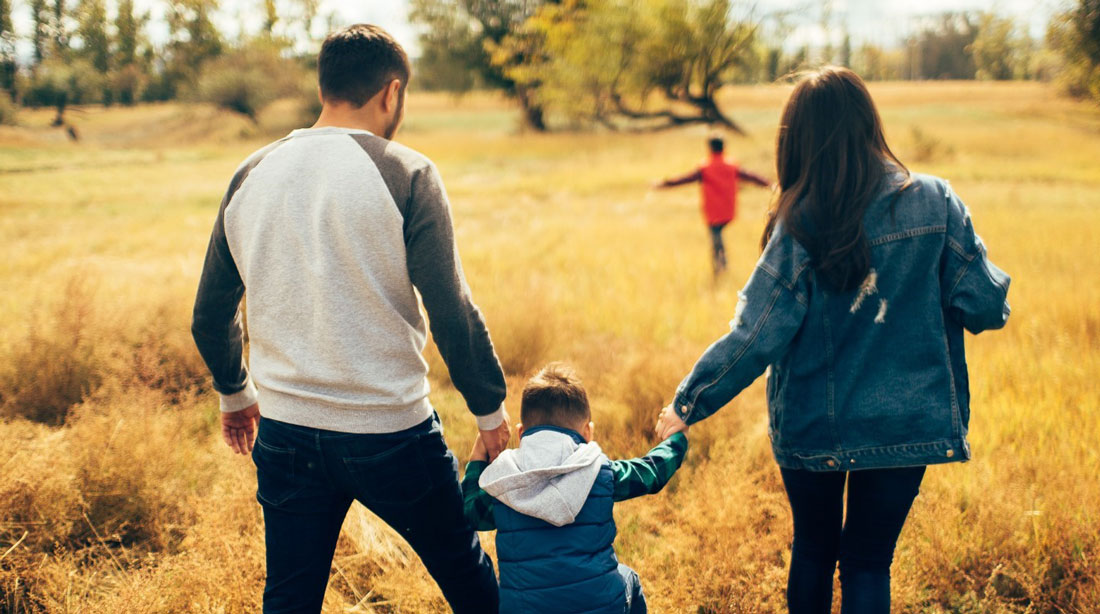 A young family holding hands